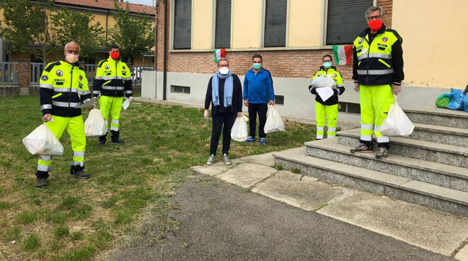 Volontari e amministratori al lavoro per la restituzione di libri e quaderni ai bambini della primaria